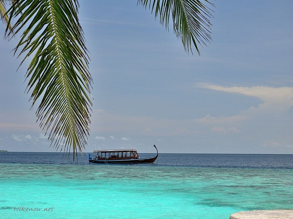 Maldives with boat around islands and reefs